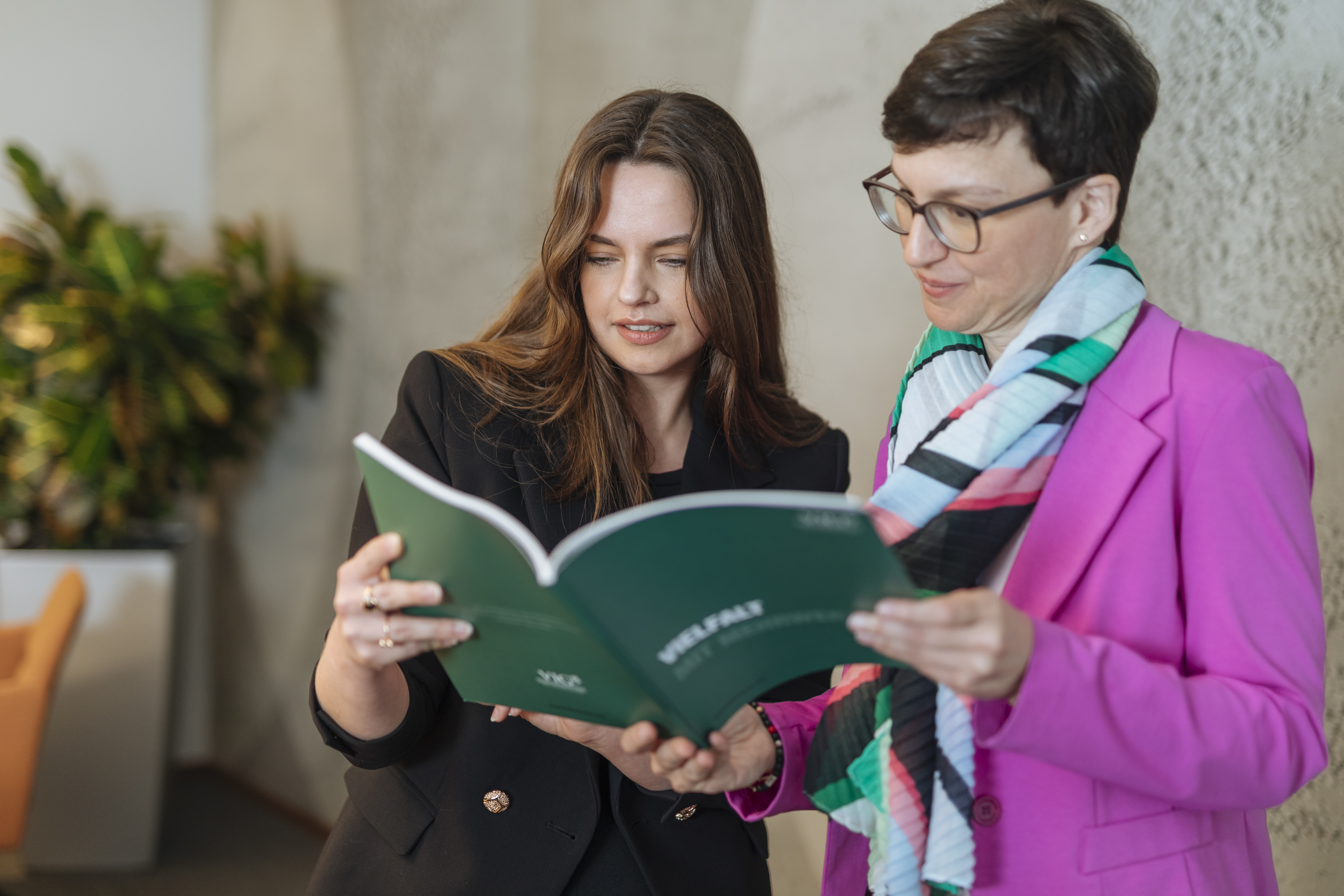 Zwei Frauen blättern in Bericht