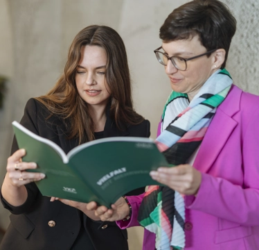 © Luxundlumen Marlene Froehlich Two women leaf through a report