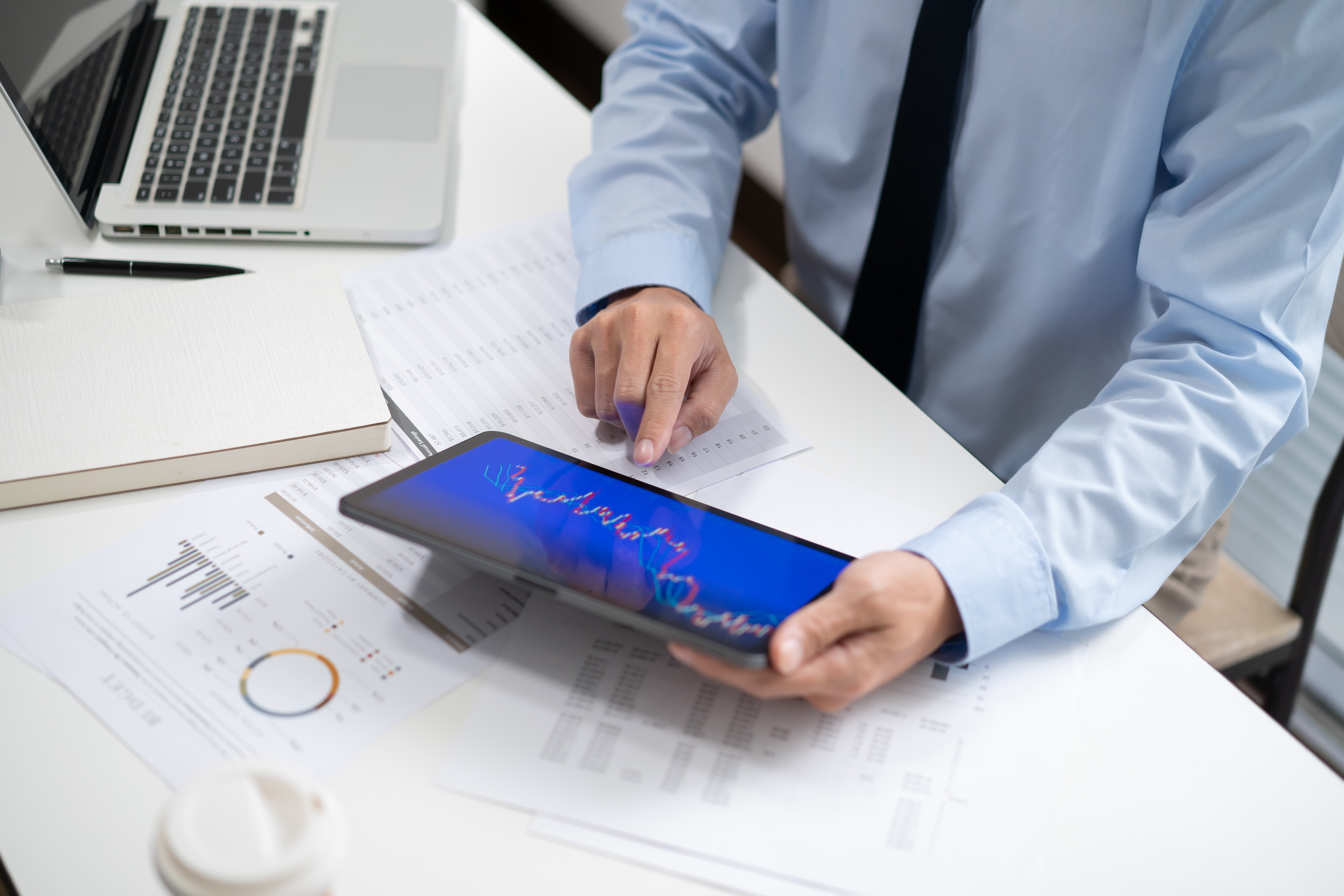 Mann analysiert Aktienkurs auf Tablet