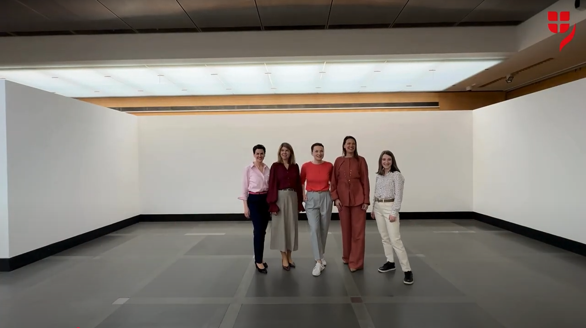 Eine Gruppe von VIG Holding Mitarbeitenden läuft in einem schnelleren Zeitraffer Tempo zusammen, winkt in die Kamera und plaudert angeregt. 