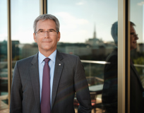 Portrait of CEO Hartwig Löger, St. Stephen's Cathedral blurred in the reflection in the background