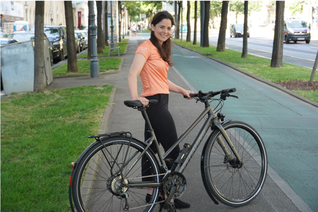 VIG Mitarbeiterin mit einem VIG Bike auf der Straße