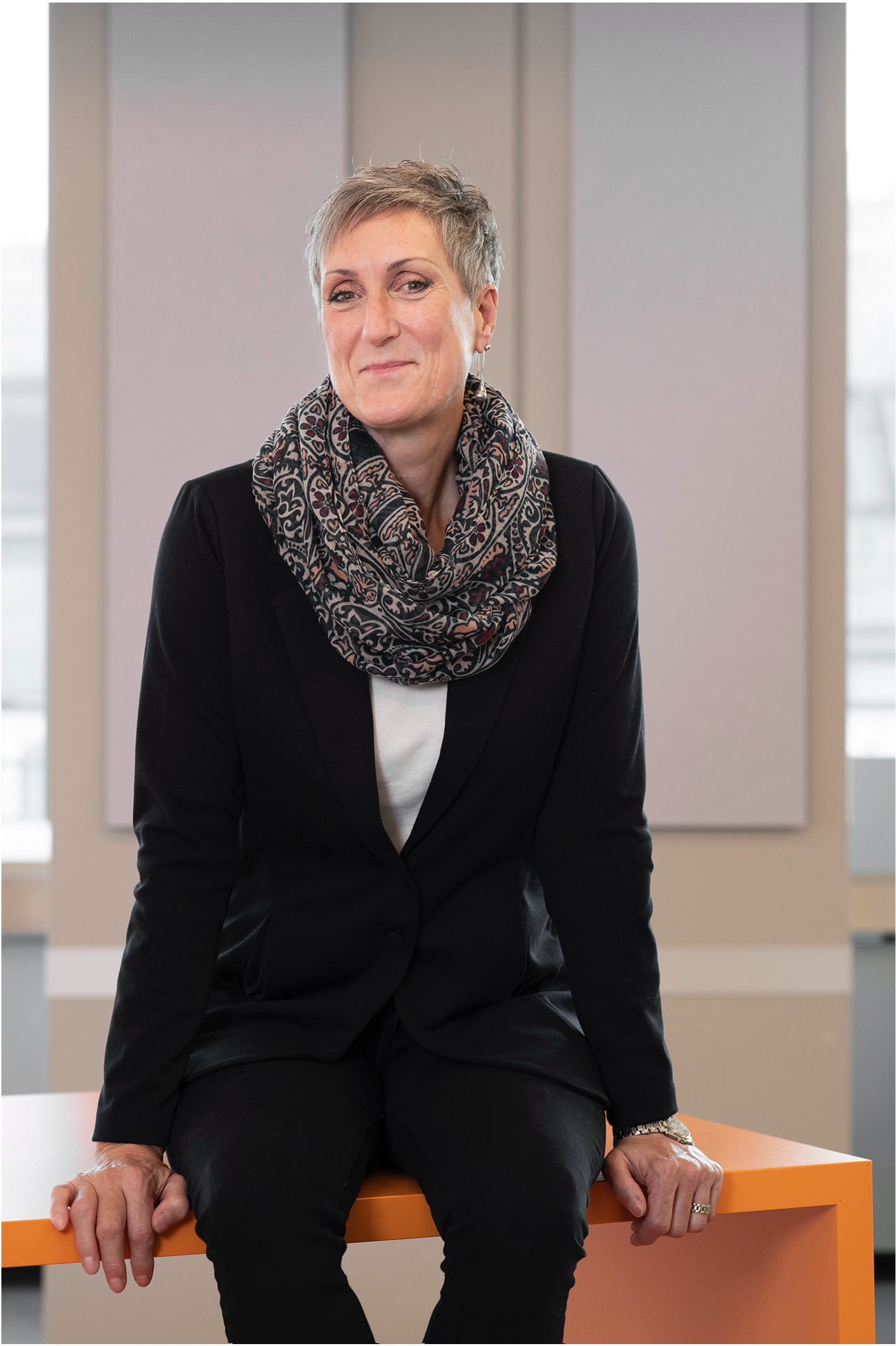 VIG employee sitting on the edge of her desk