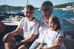 Zwei Kinder und eine Erwachsene auf einem Boot der Mirno More Friedensflotte