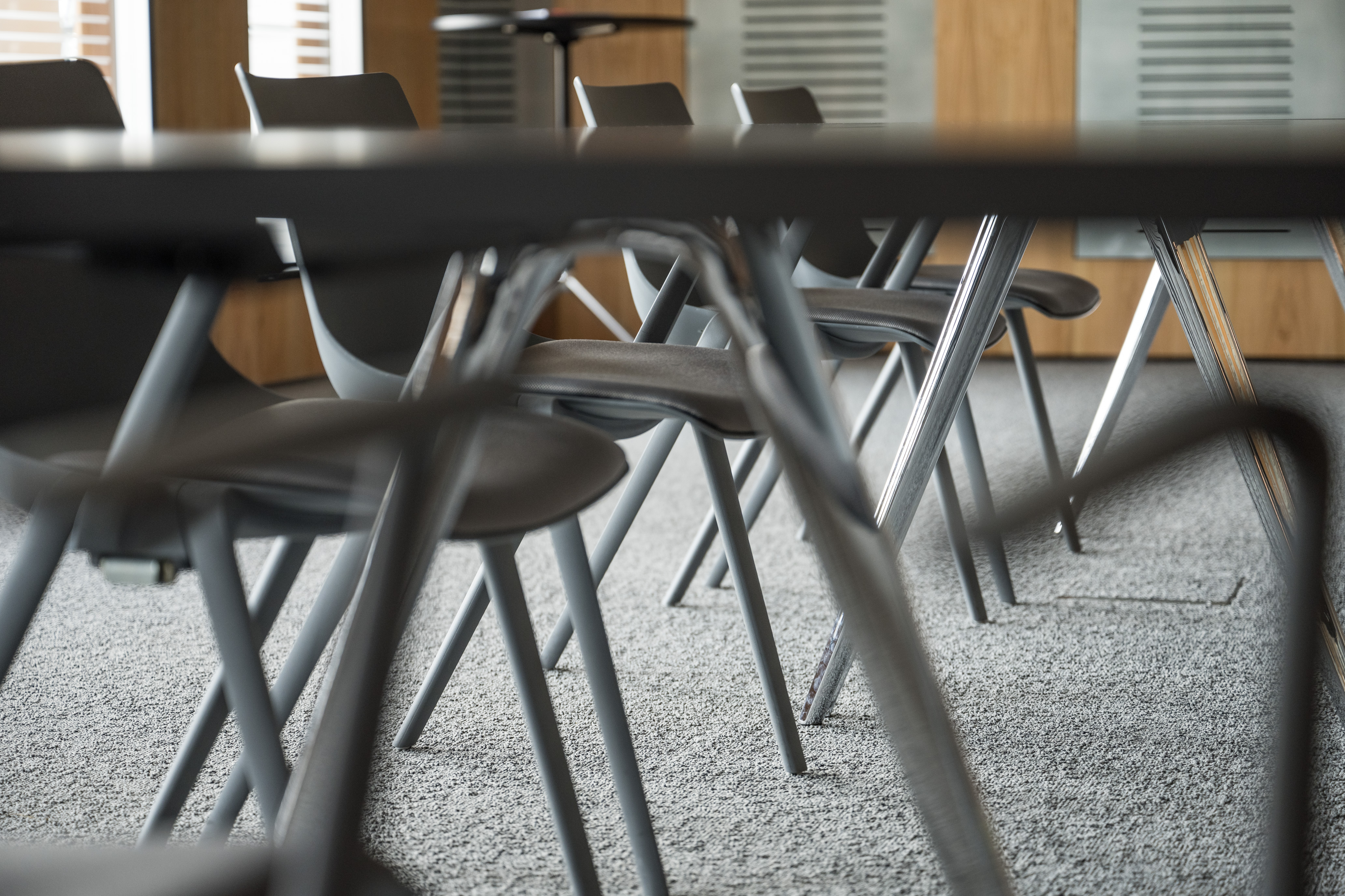 Konferenzraum mit grauen Sesseln, Tischen und Teppich