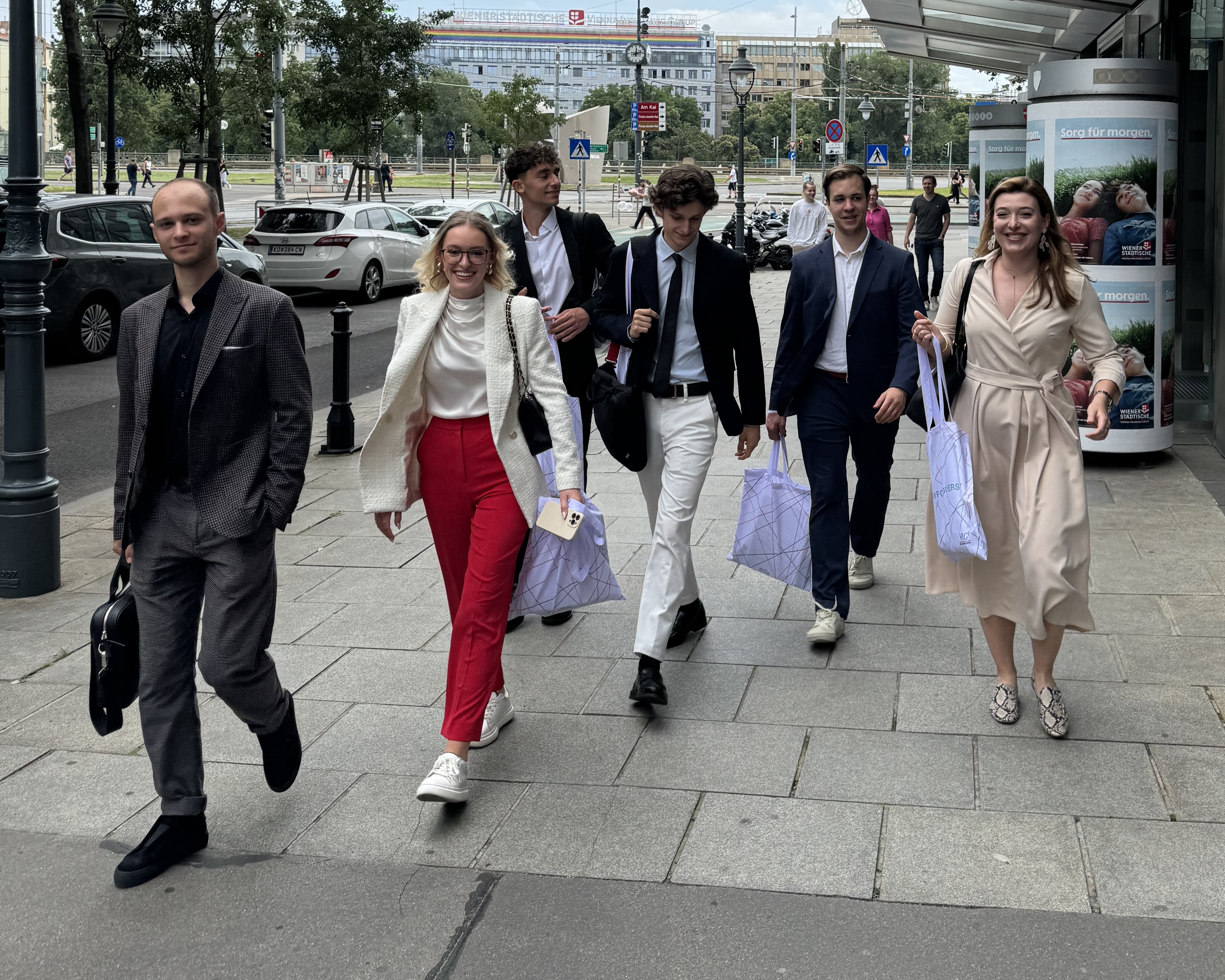 Studierende und Absolvent:innen vor dem Eingang des VIG Gebäudes