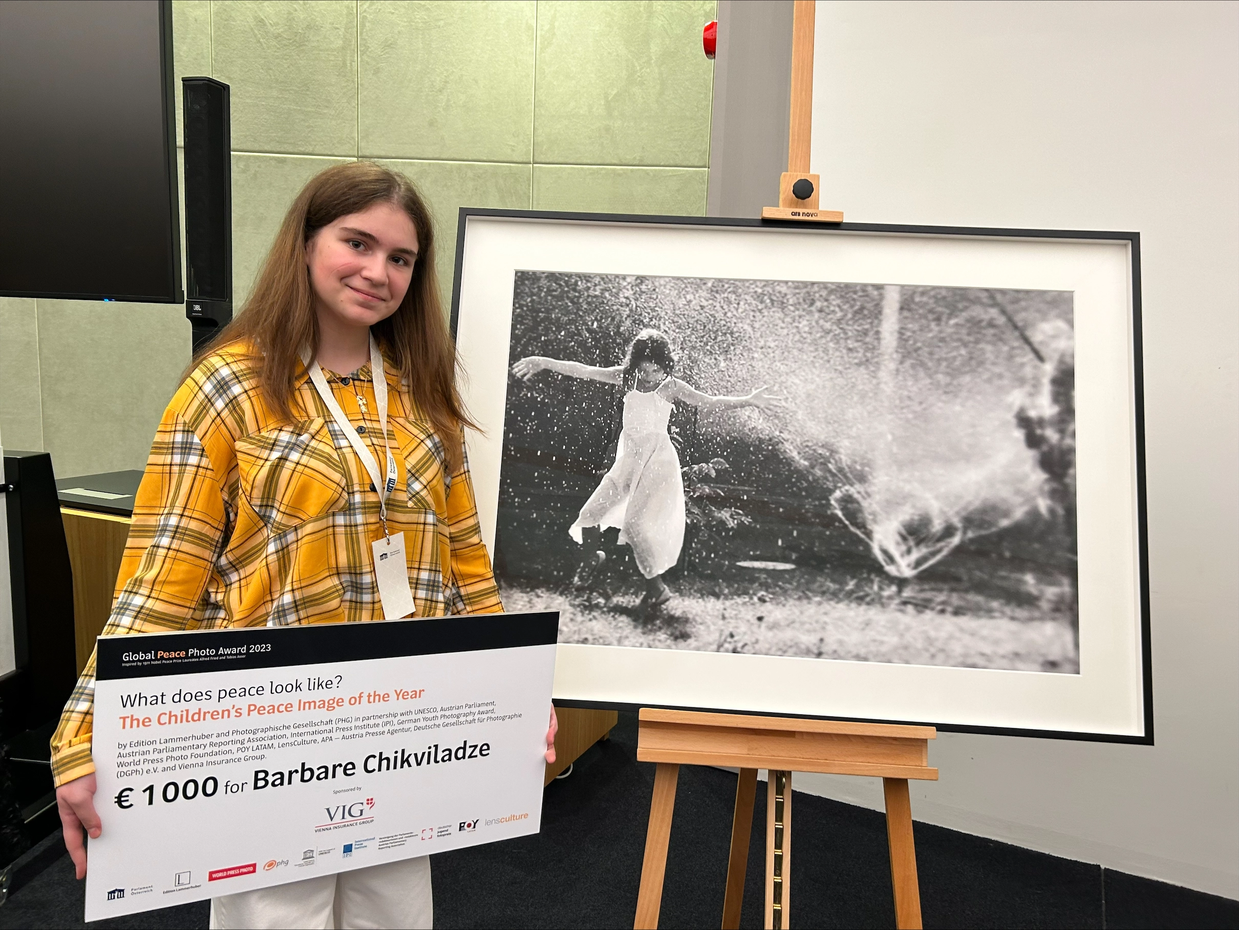 Barbare Chikviladze, winner of the children's peace picture, poses with her picture and the check