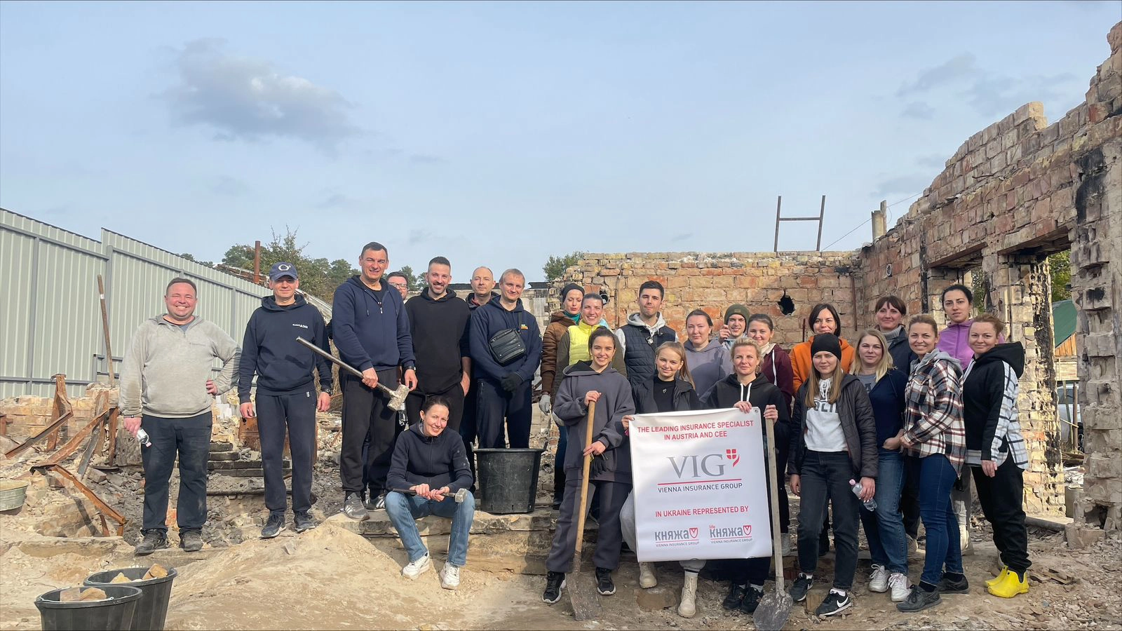 © Kniazha Group photo of the Ukrainian VIG colleagues on their Social Active Day with VIG and Kniazha logos on a poster