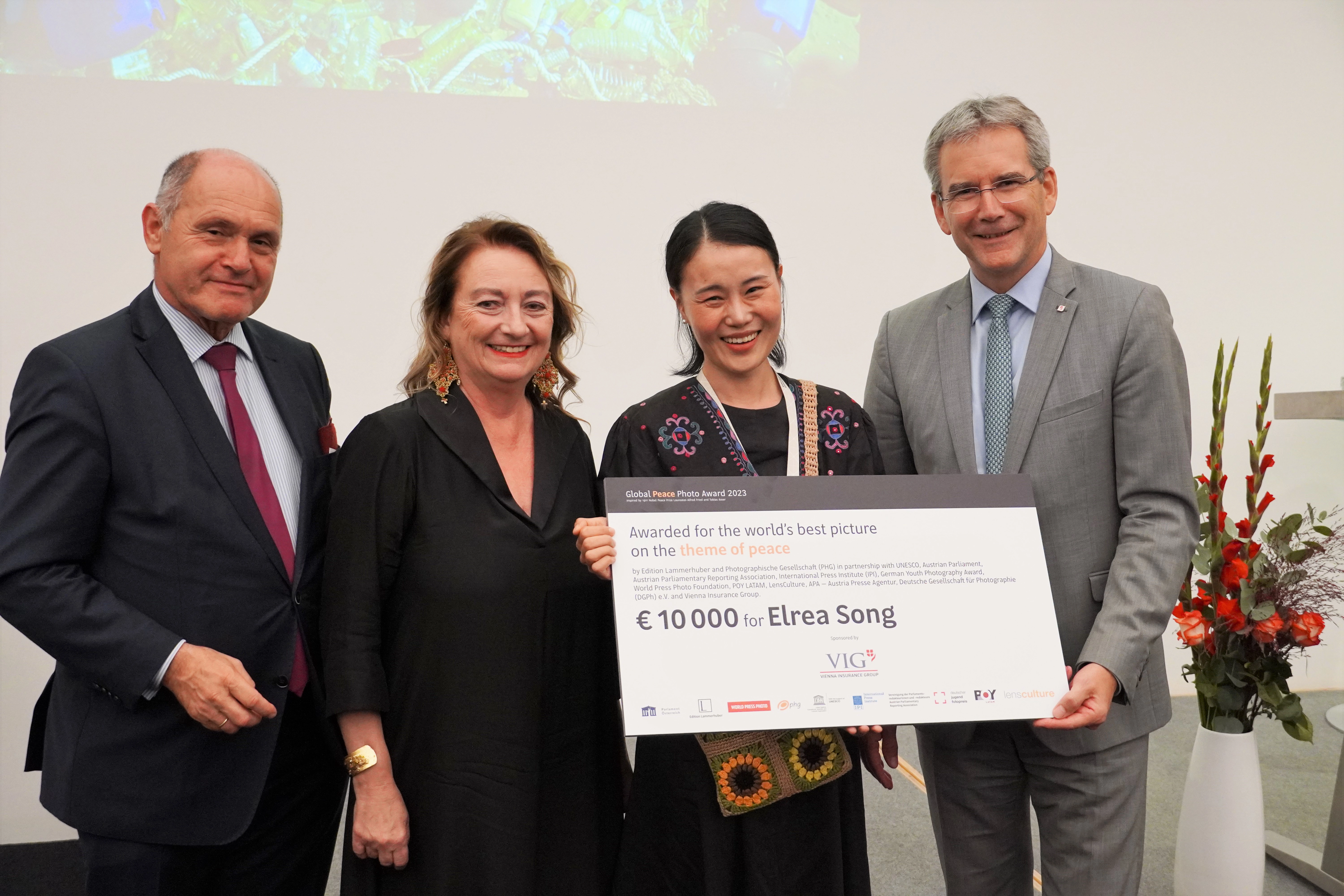 Hartwig Löger presents the award to the winner of the “Peace Image of the Year 2023”, Elrea Song