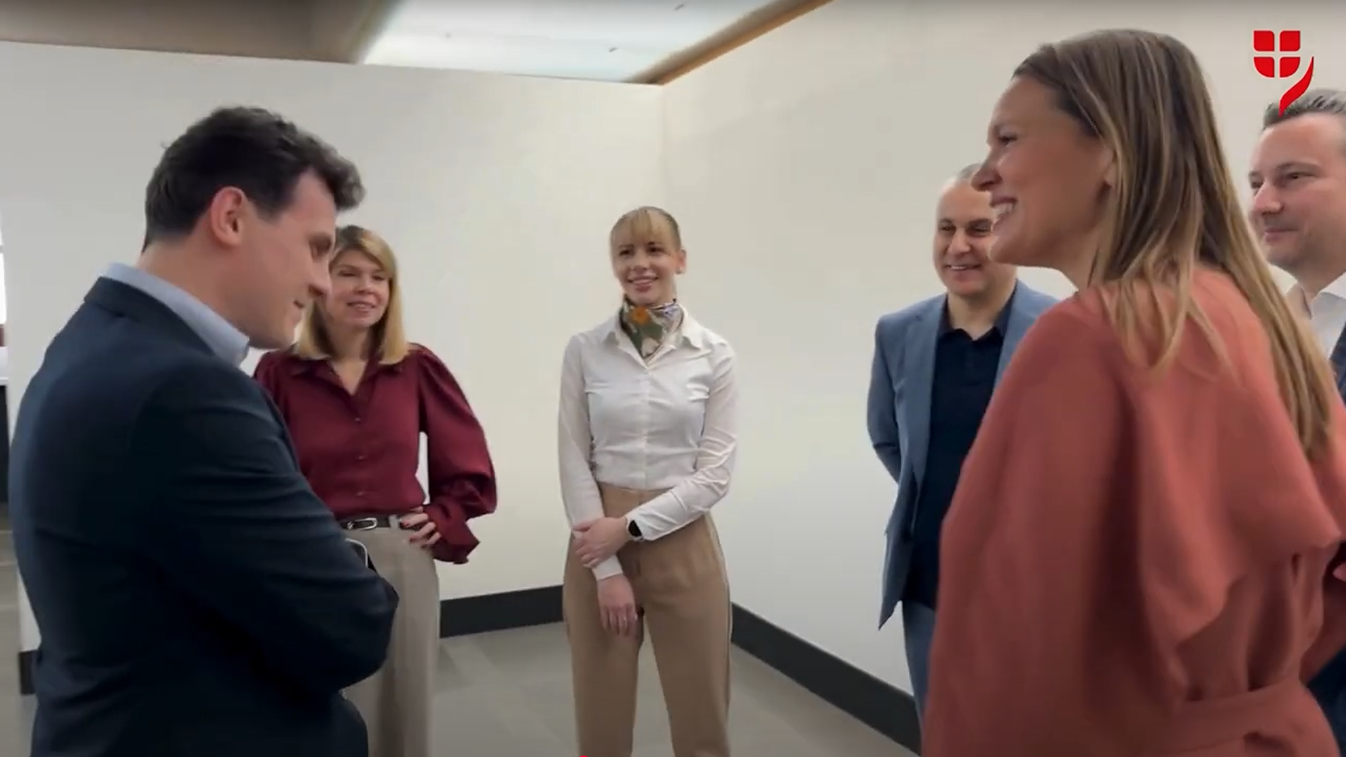 Eine Gruppe von VIG Holding Mitarbeitenden aus unterschiedlichen Herkunftsländern stehen locker verteilt und unterhalten sich.