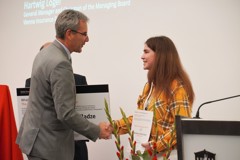 Hartwig Löger gratuliert der Siegerin des Kinder-Friendensbilds, Barbare Chikviladze.