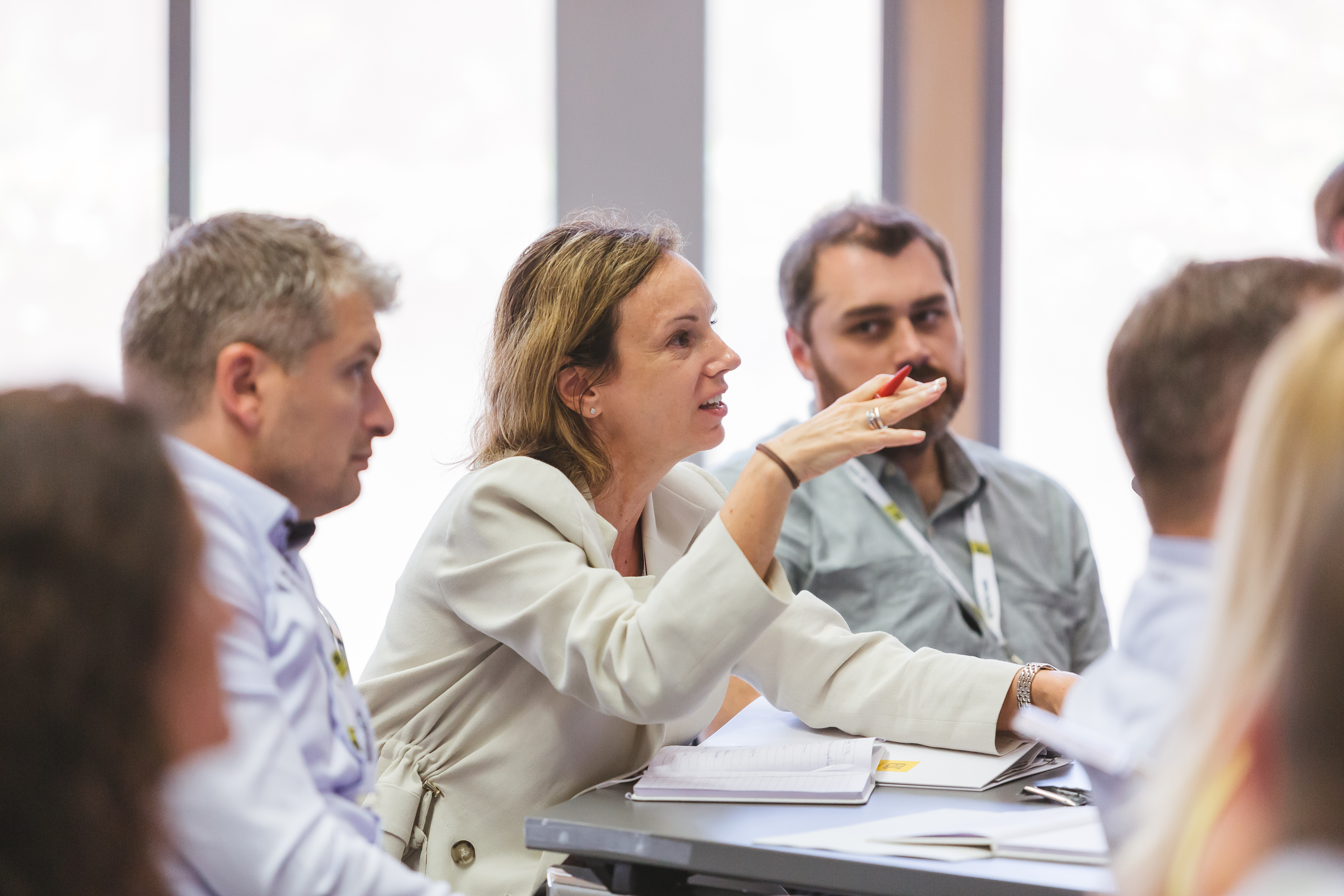Female leader in the plenary explains something for the trainer