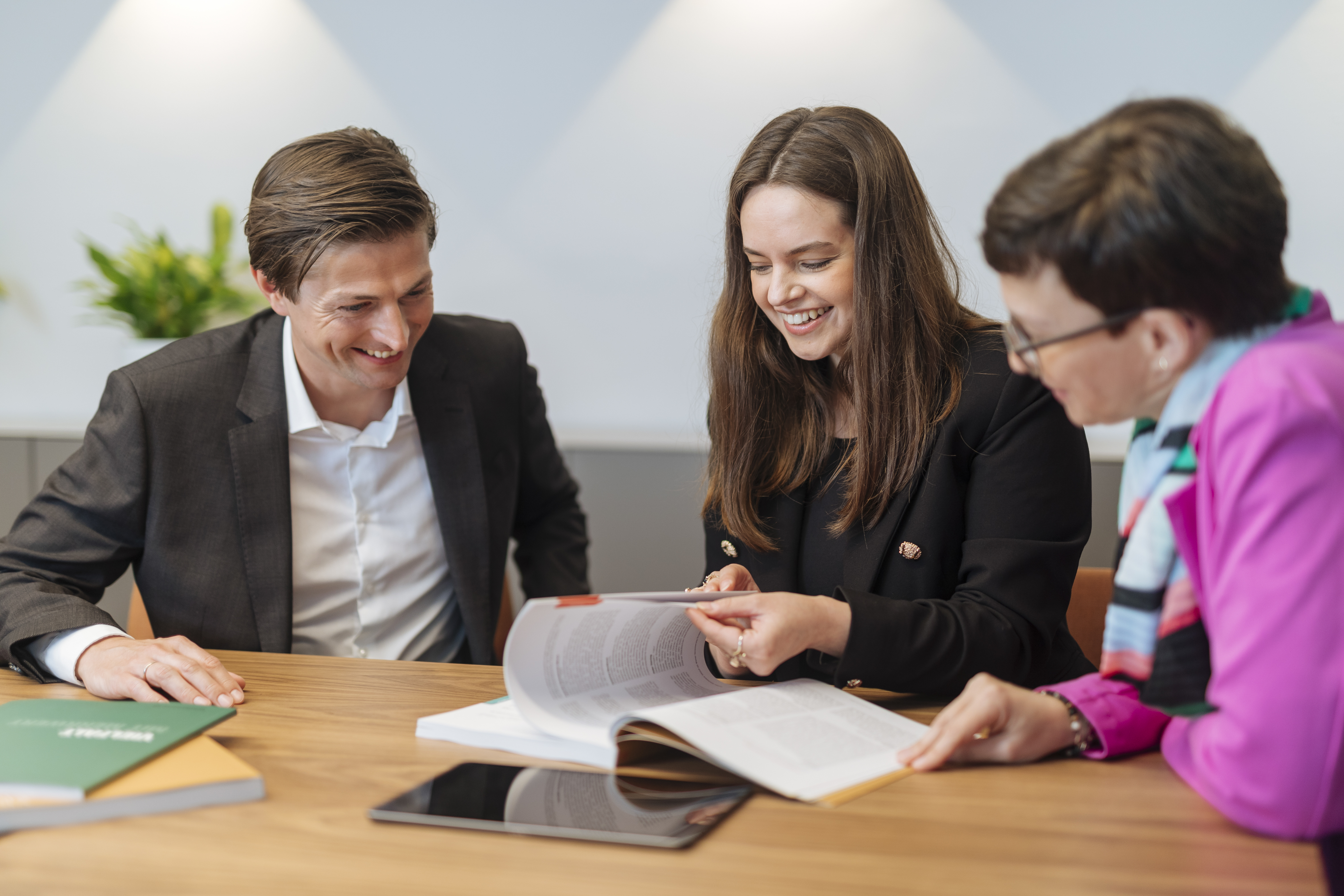 Mitarbeitende blättern in Bericht