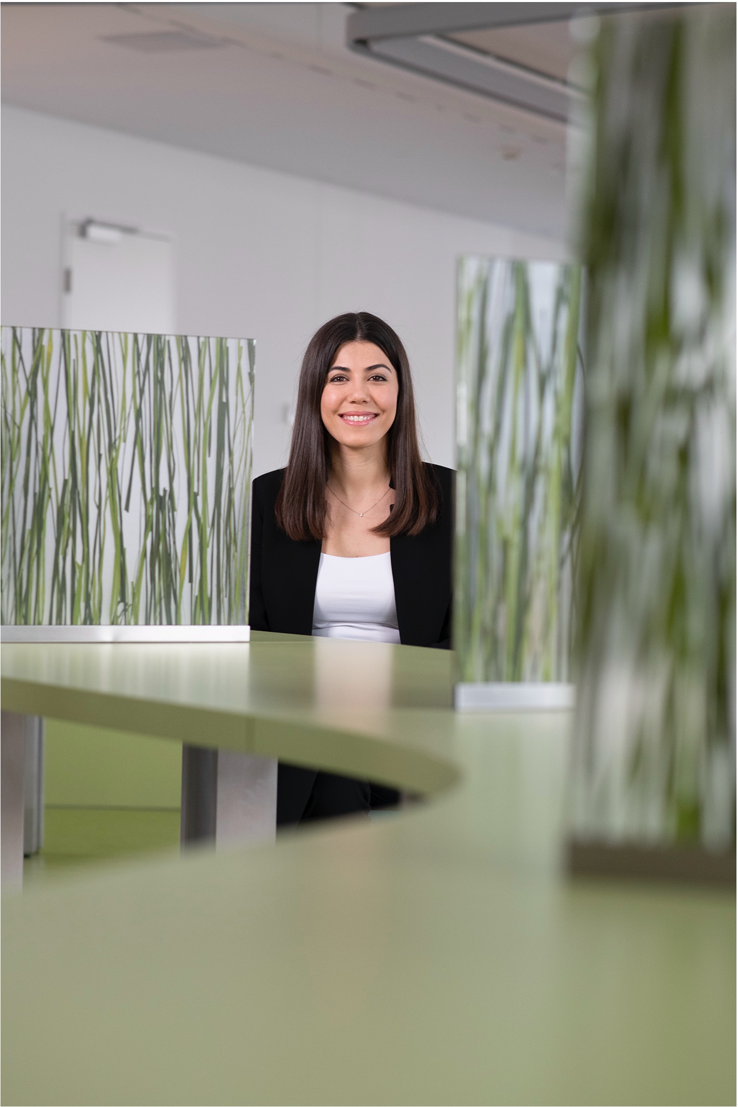 VIG employee sitting in the canteen between green see through separating walls