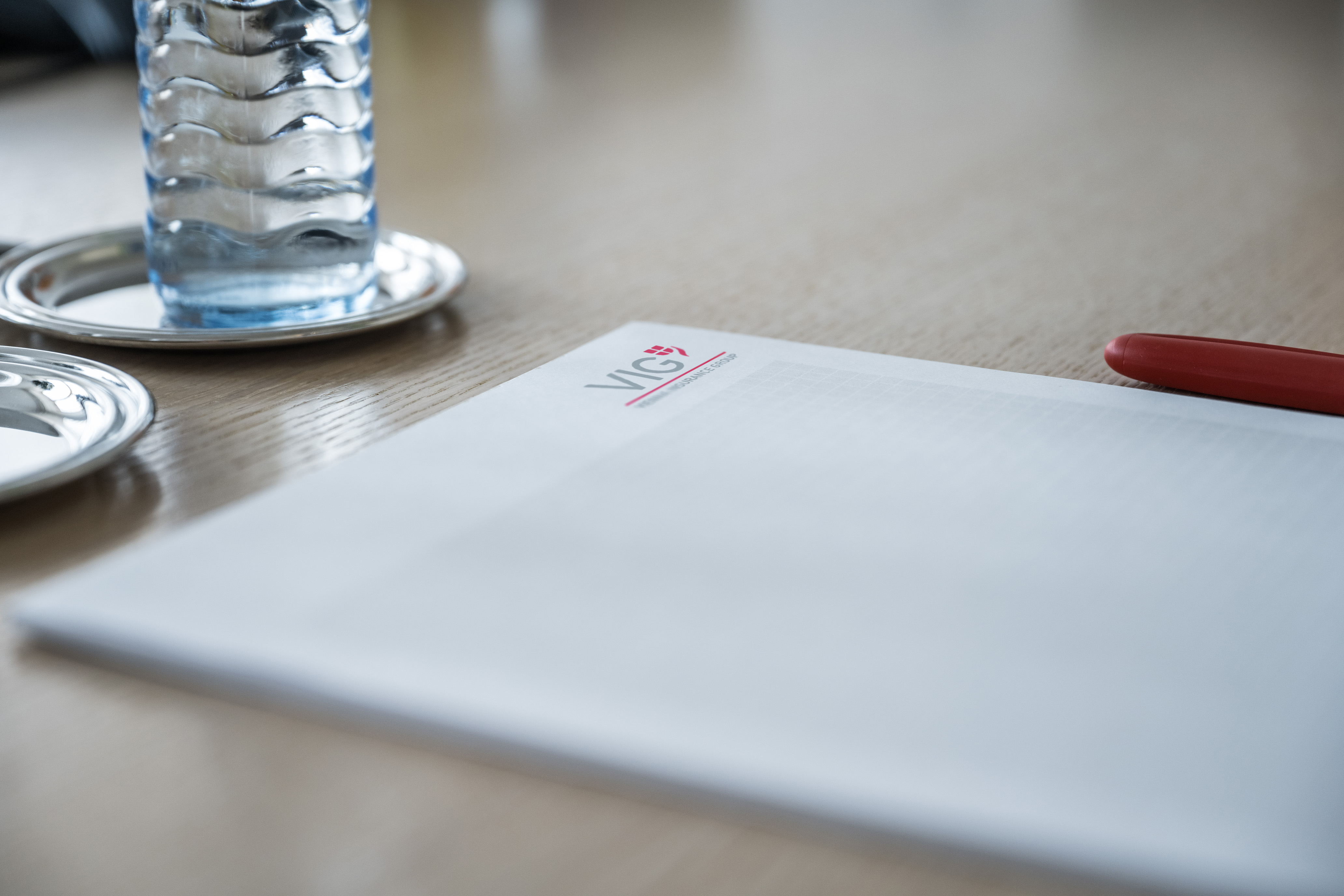 Writing pad with VIG logo, biro, water bottle on desk