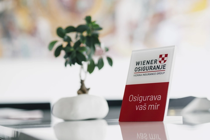 © Wiener Osiguranje Aufsteller mit dem Logo der Wiener Osiguranje steht auf einem Tisch