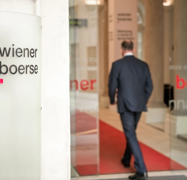 © Wiener Börse APA Fotoservice Mann tritt durch Glastüren in das Gebäude der Wiener Börse