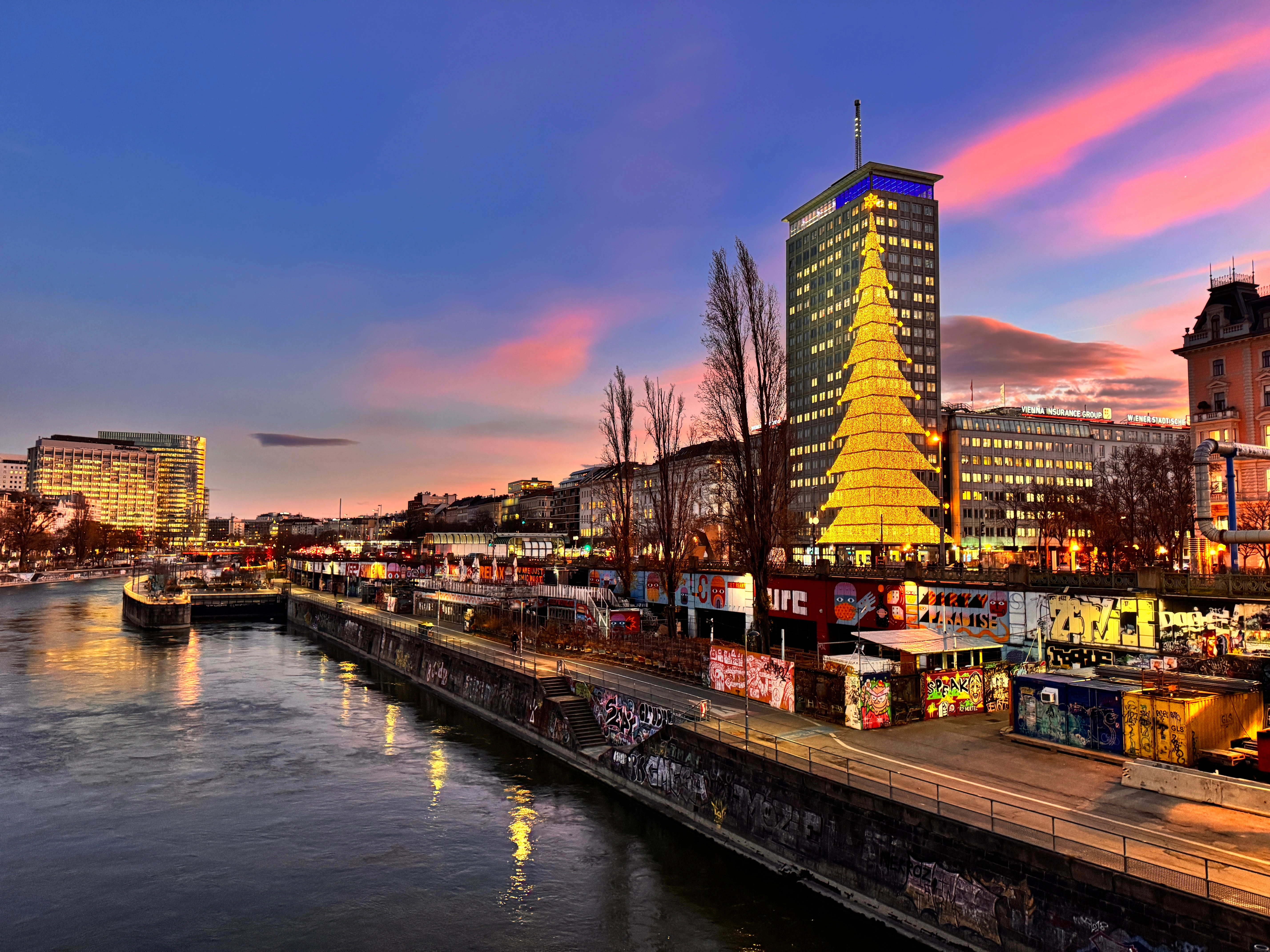 Weihnachtlicher Ringturm mit weihnachtsbaumförmiger Beleuchtung in der Morgendämmerung.