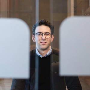 © Laurent Ziegler VIG employee is sitting in the entrance area behind branded glass doors