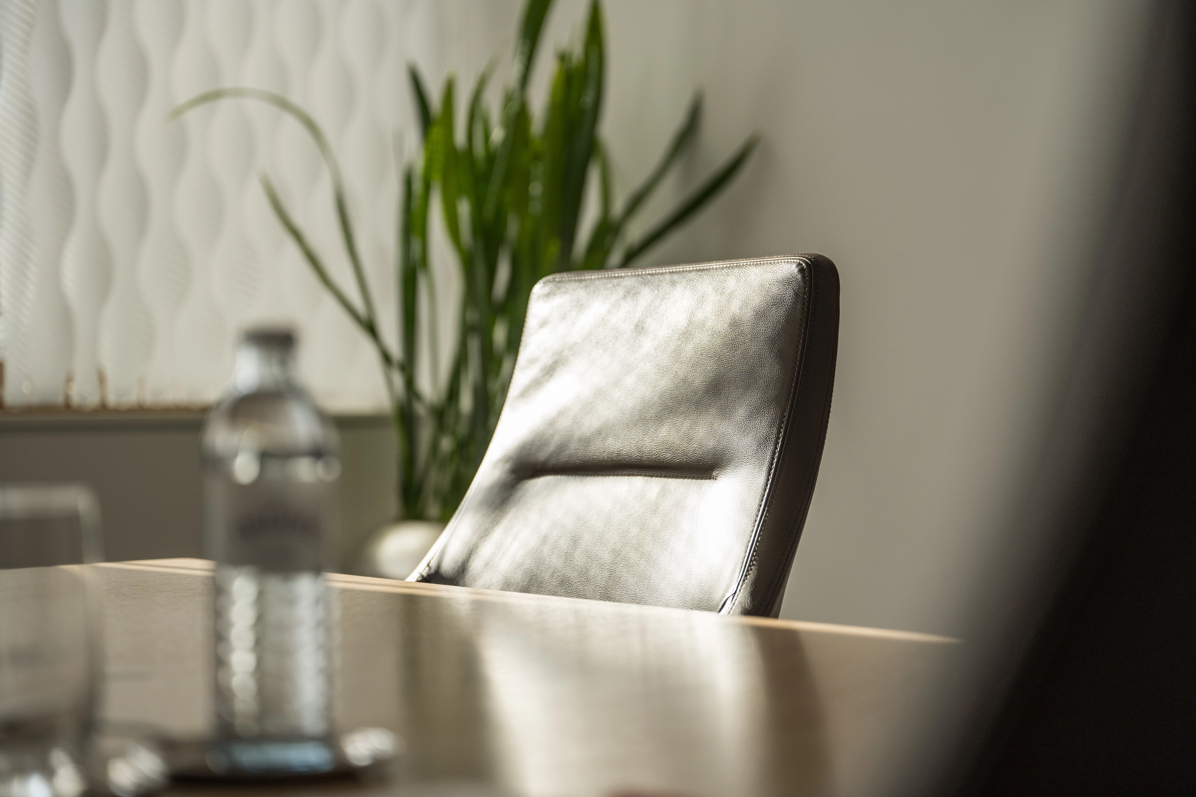 © Jakob Waldhör/kraftwerk Meeting room still life: Black meeting room chair with plant in the background.