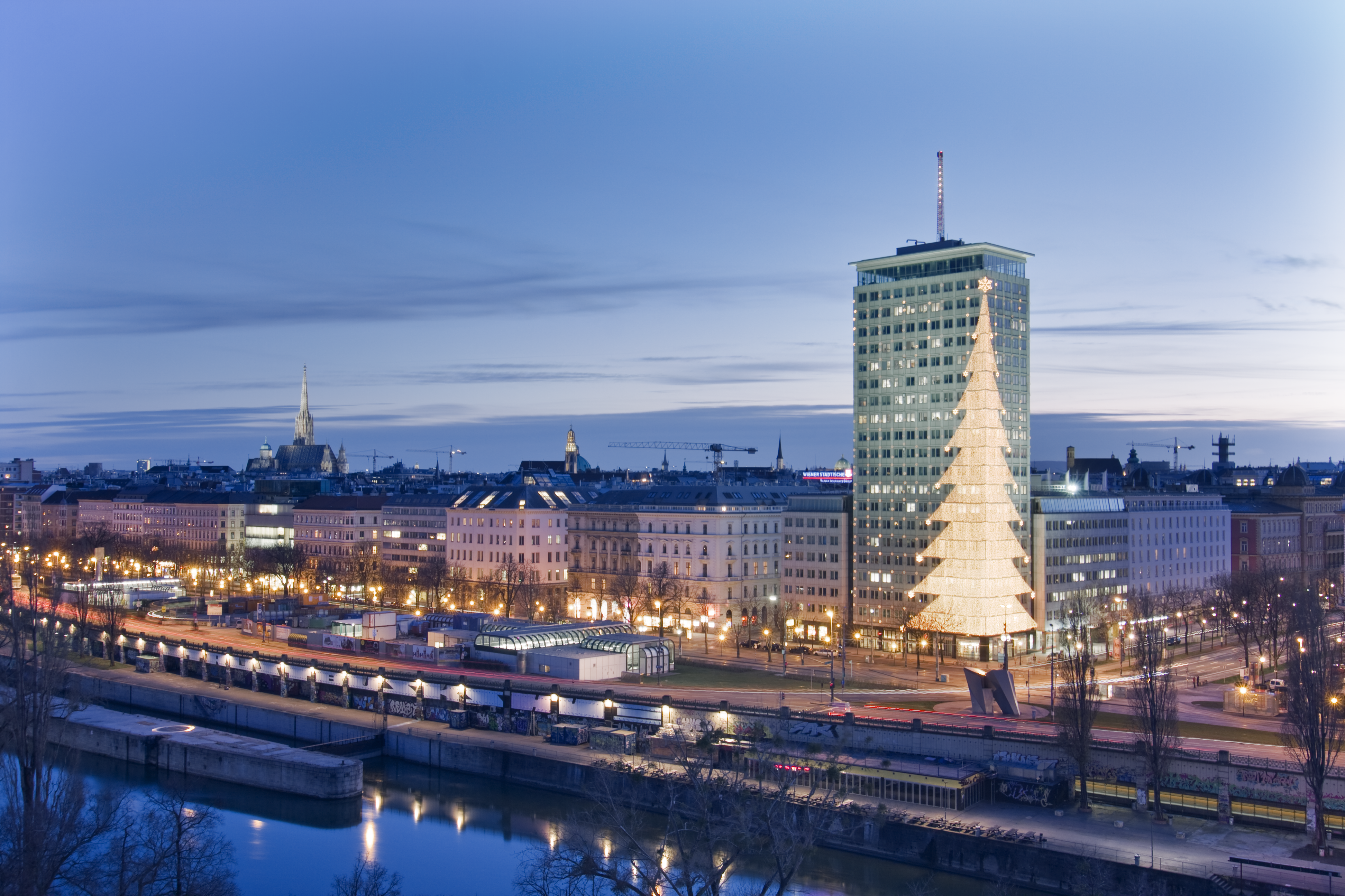 Ringturm mit weihnachtbsaumförmiger Beleuchtung in der Dämmerung.